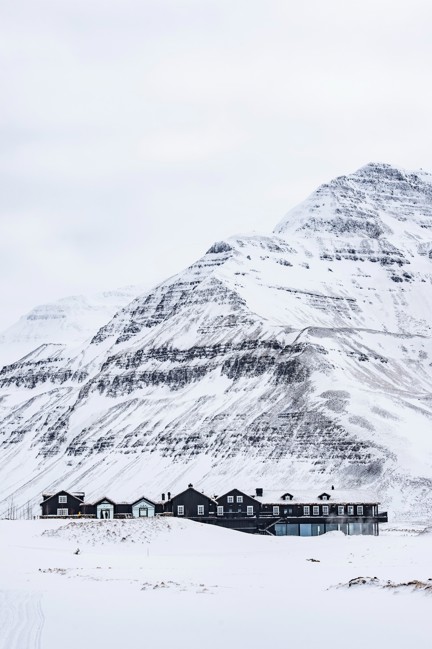 Deplar Farm covered in snow with a mountain behind it.